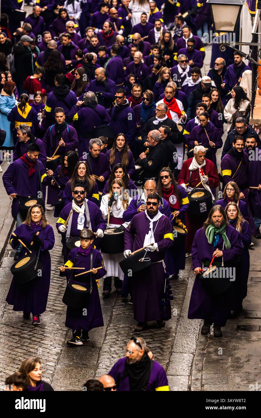 Turbas de Cuenca in purple robes make a deafening noise with their drums (tambores) and trumpets (clarines) at the head of the Camino del Calvario procession, which passes through Cuenca on Good Friday. Plaza Mayor, Cuenca, Castilla-La Mancha, Spain Stock Photo