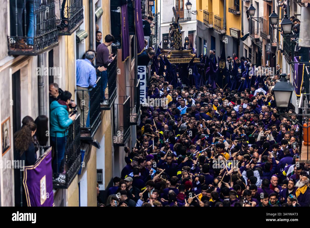 Turbas de Cuenca in purple robes make a deafening noise with their drums (tambores) and trumpets (clarines) at the head of the Camino del Calvario procession, which passes through Cuenca on Good Friday. Plaza Mayor, Cuenca, Castilla-La Mancha, Spain Stock Photo