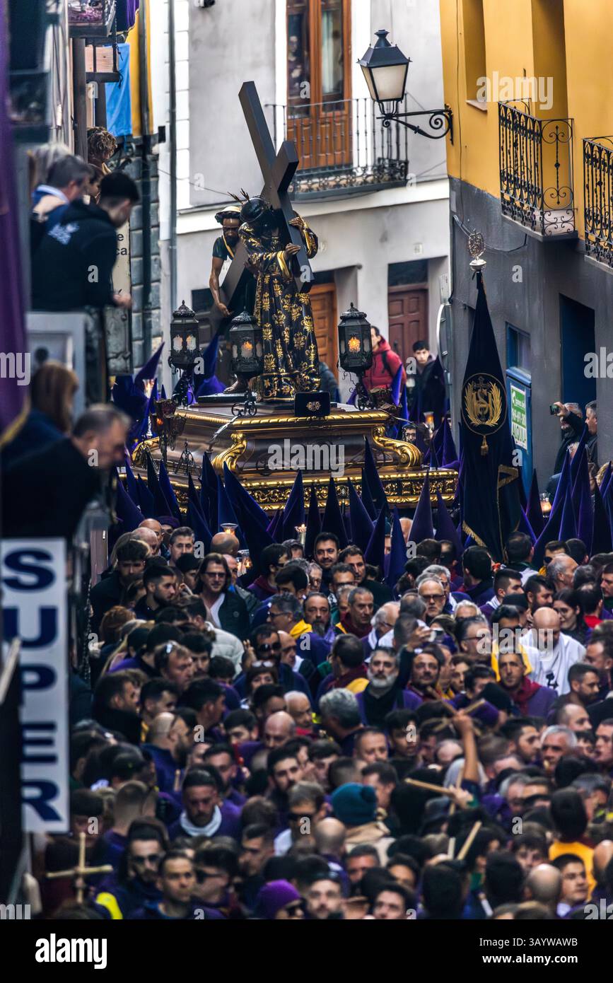 Turbas de Cuenca in purple robes make a deafening noise with their drums (tambores) and trumpets (clarines) at the head of the Camino del Calvario procession, which passes through Cuenca on Good Friday. Plaza Mayor, Cuenca, Castilla-La Mancha, Spain Stock Photo
