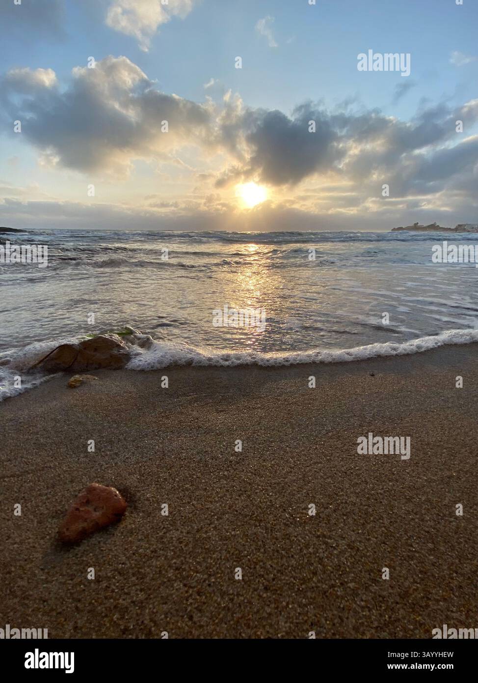 Soft waves gently lapping against golden sand on the beach at sunrise ...