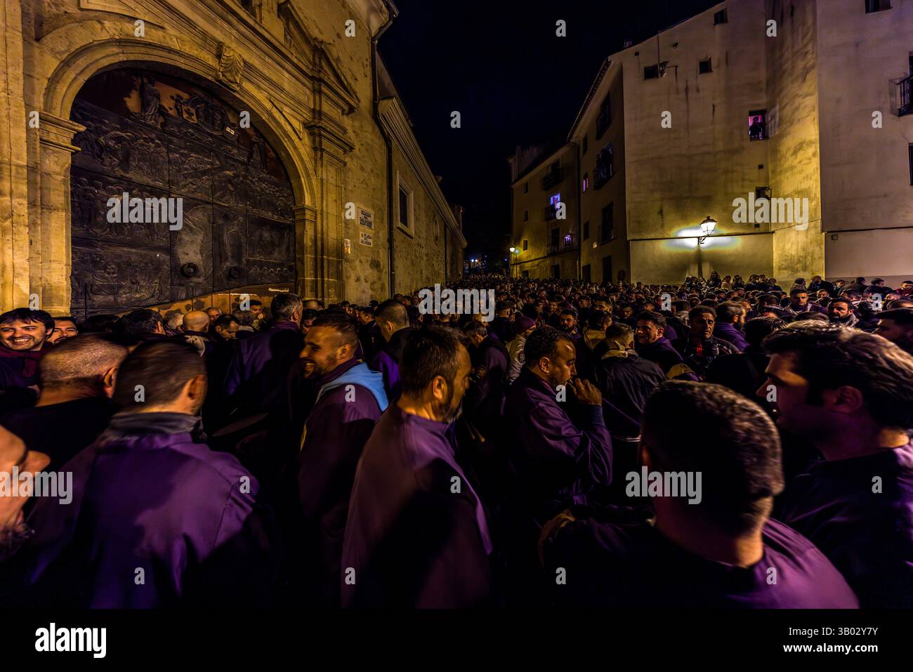 The Turbas de Cuenca have stayed awake through the night before Good Friday. In front of the parish church of El Salvador, they make enough noise to be heard throughout Cuenca for hours before the procession begins. Plaza Salvador, Cuenca, Castilla-La Mancha, Spain. The Turbas tradition dates back to their first procession on 4 April 1616. Members, known as turbos, wear the robes of their brotherhoods and play homemade drums and tin trumpets. The trumpets' off-key sound is called clariná, the drumbeat palillá. During Semana Santa in Cuenca, 33 Hermandades take part in eleven processions throug Stock Photo
