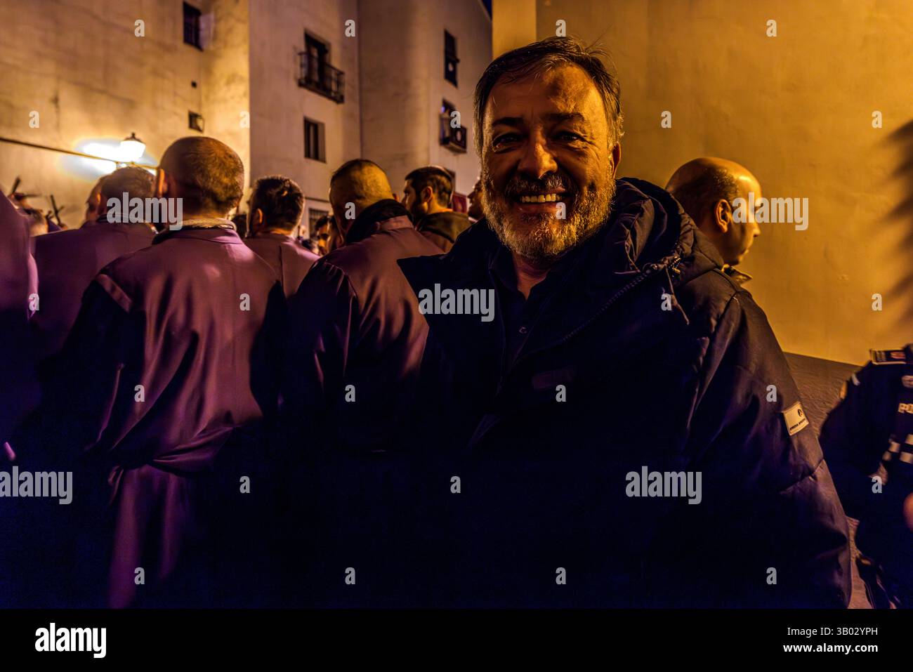 The mayor of Cuenca, Daró Dolz Fernández, attends the start of the Good Friday procession. Turbas de Cuenca in purple robes make a deafening noise in front of the Iglesia Parroquial de El Salvador in the middle of the night at the beginning of Good Friday. Plaza Salvador, Cuenca, Castilla-La Mancha, Spain Stock Photo