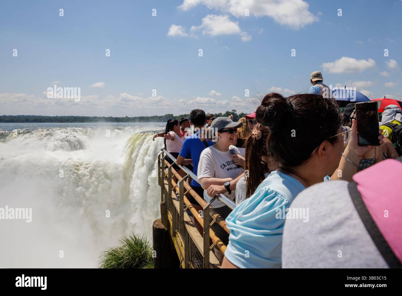Puerto Iguazu, Misiones, Argentina - April 5th, 2025: Tourists watching the Devil's Throat waterfall at Iguazu Falls. Stock Photo