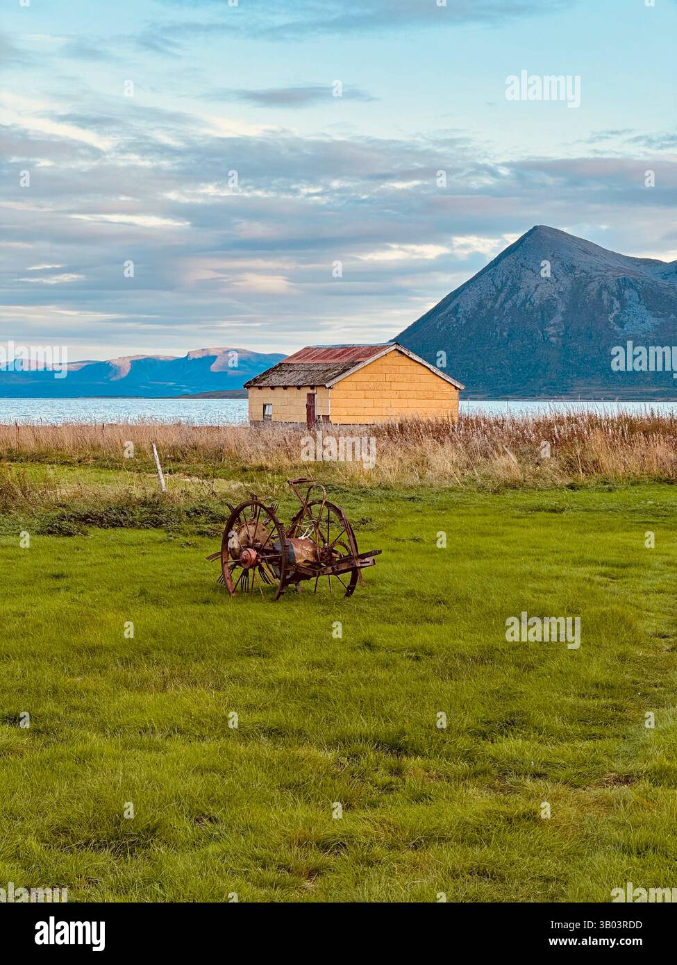 A small cabin surrounded by mountains and lush green grass - Smartphone Captured Stock Image A small cabin surrounded by mountains and lush green grass - Smartphone Captured Stock Image
