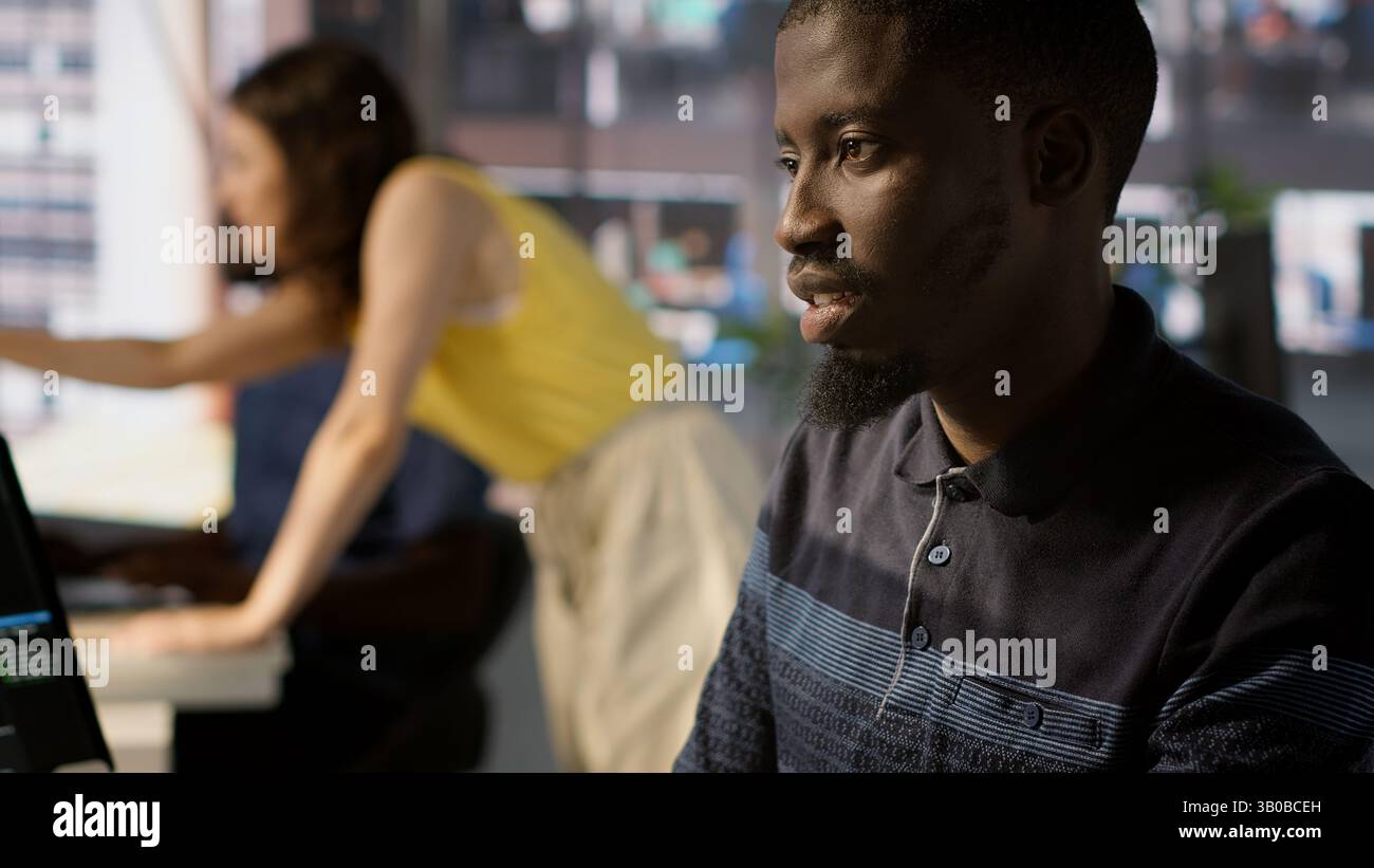 System administrator doing software quality assurance, checking source code on tablet. Close up of african american IT specialist at work inspecting coding on device, looking to fix errors, camera A Stock Photo