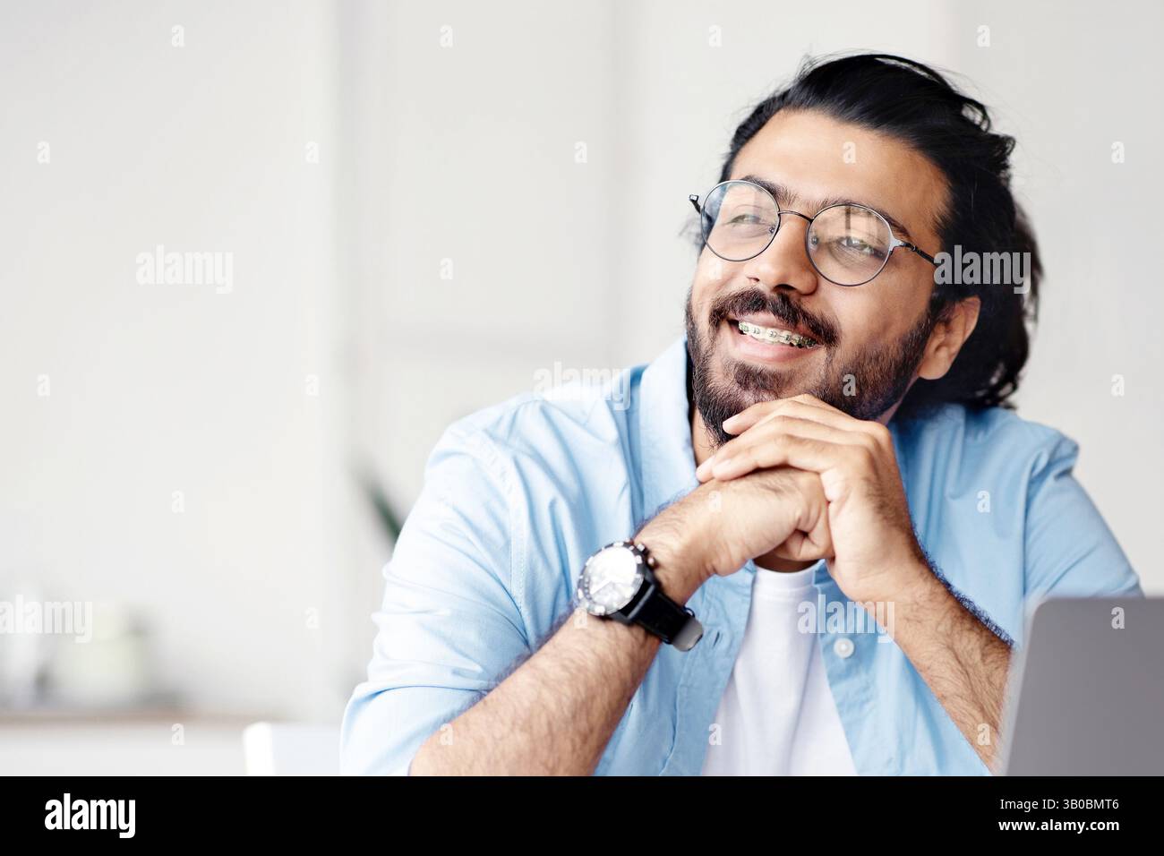 Pensive freelancer thinking about something while working on laptop at home office Stock Photo