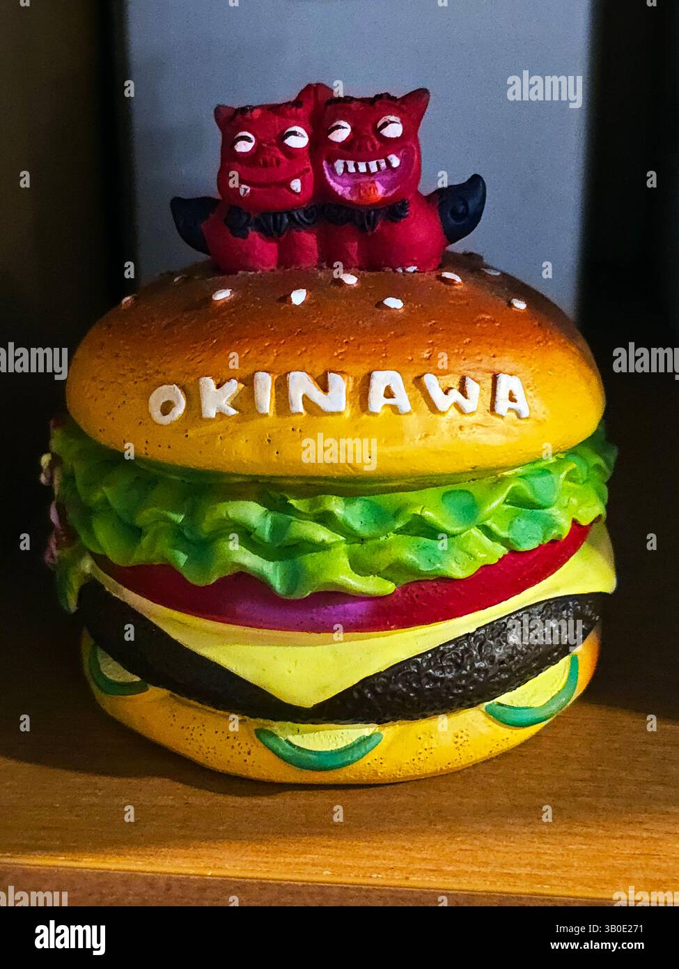 A Cheeseburger with Shisa guardians' souvenir from Okinawa, Japan. - Smartphone Captured Stock Image