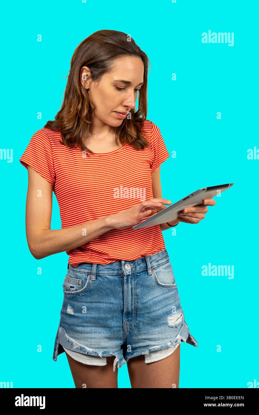 Casual dressed female using electronic device, browsing internet or reading e-book Stock Photo