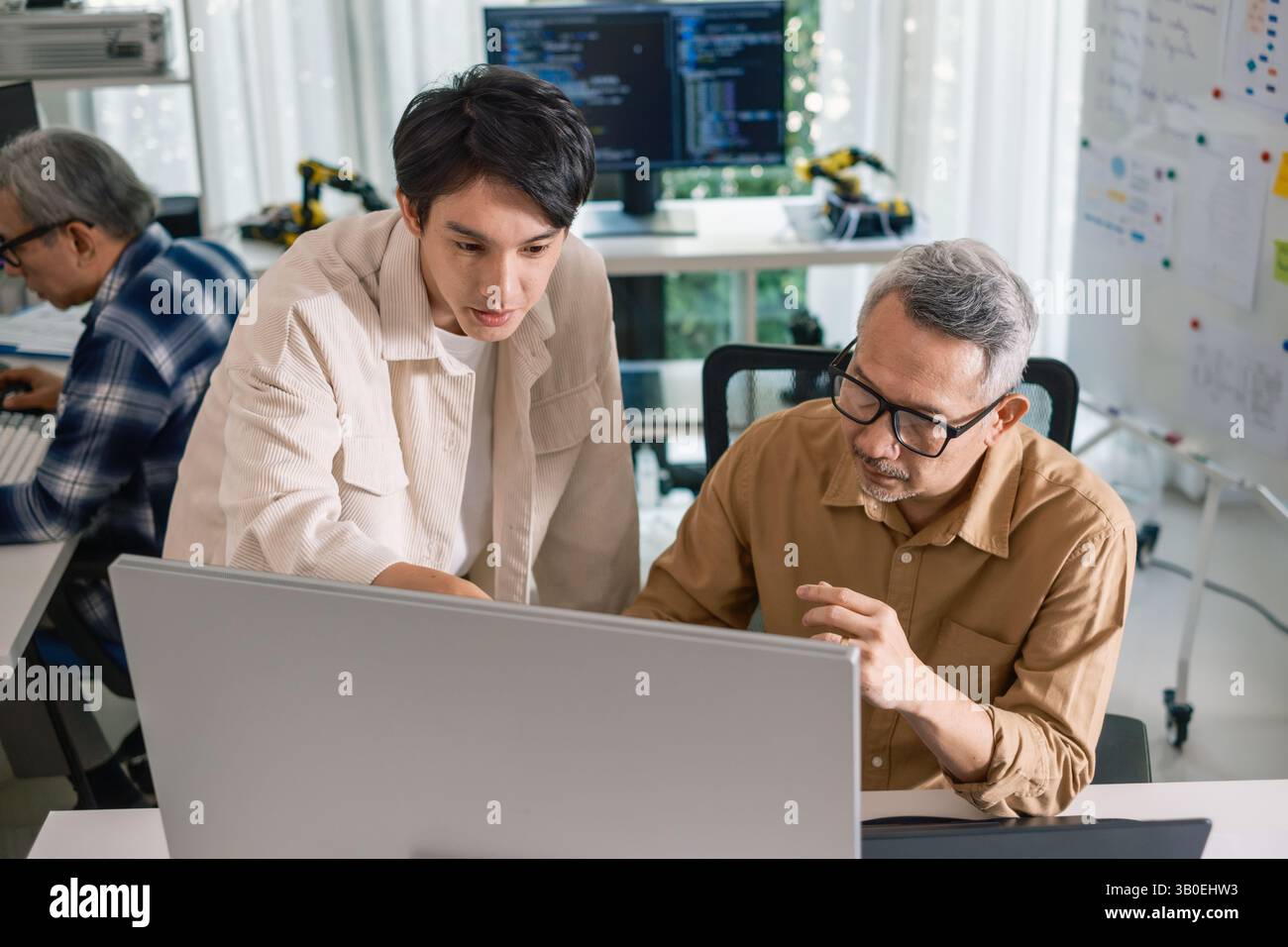 Group of asian senior in a collaborative software development analyzing flowcharts during a bootcamp training Stock Photo