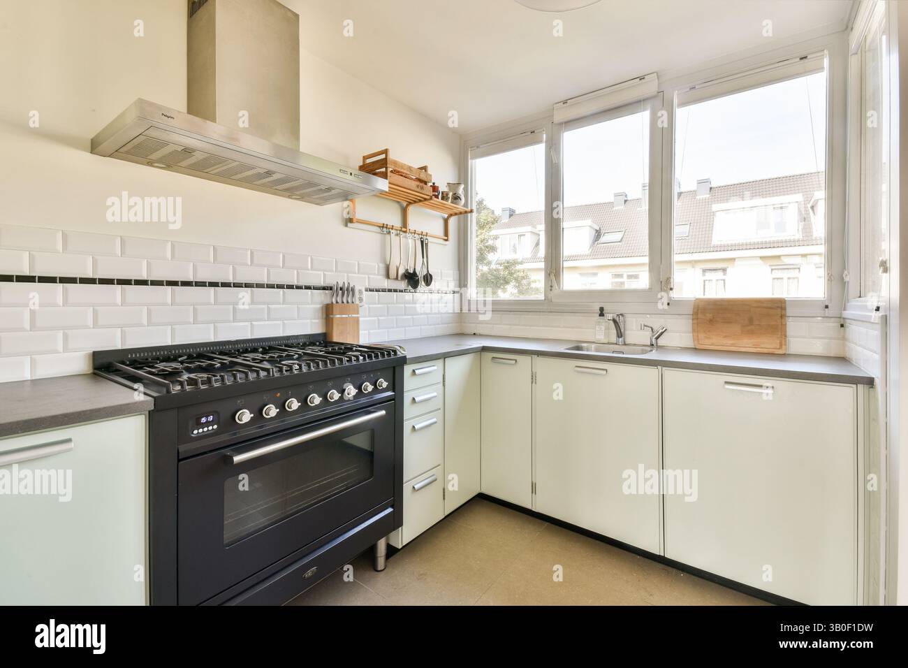 A sleek modern kitchen featuring minimalist design, large windows ...