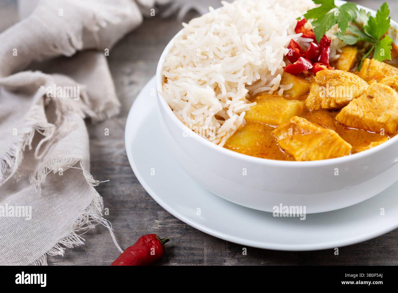 Massaman curry in bowl on wooden table. Traditional Thai food recipe. Stock Photo