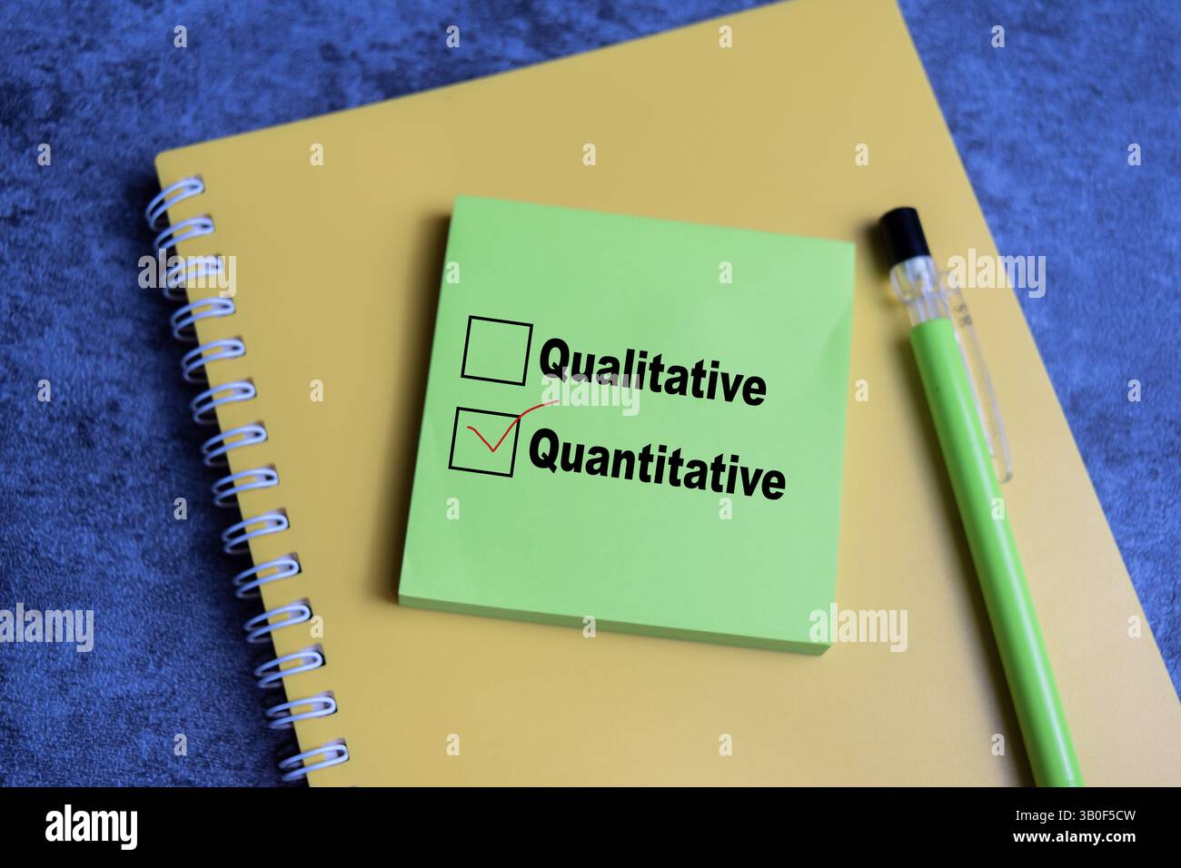 Concept of one person is answering question. he is choosing between qualitative and quantitative write on sticky notes isolated on Wooden Table. Stock Photo