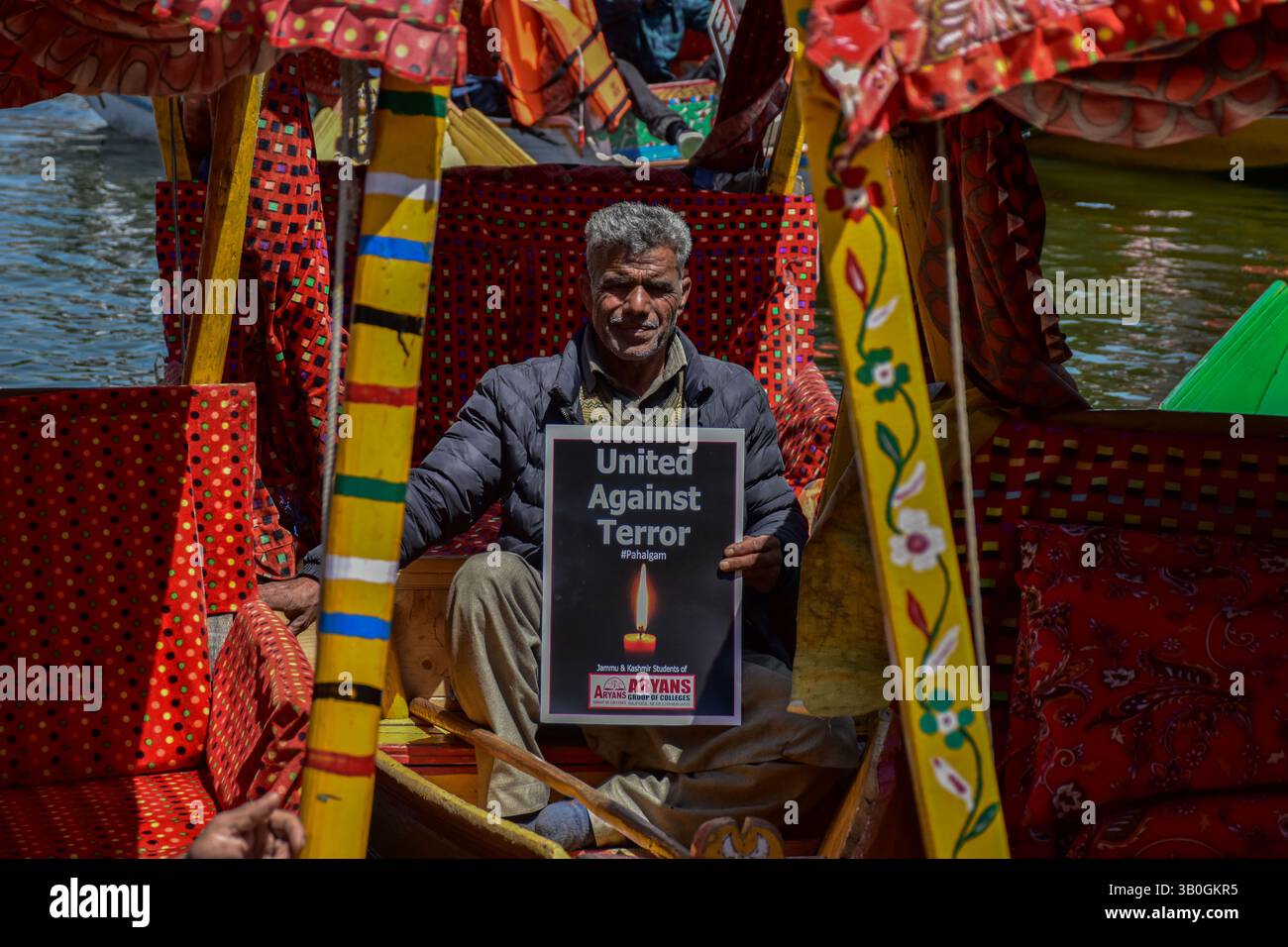 Srinagar, India. 24th Apr, 2025. A Kashmiri boatman holds a placard ...