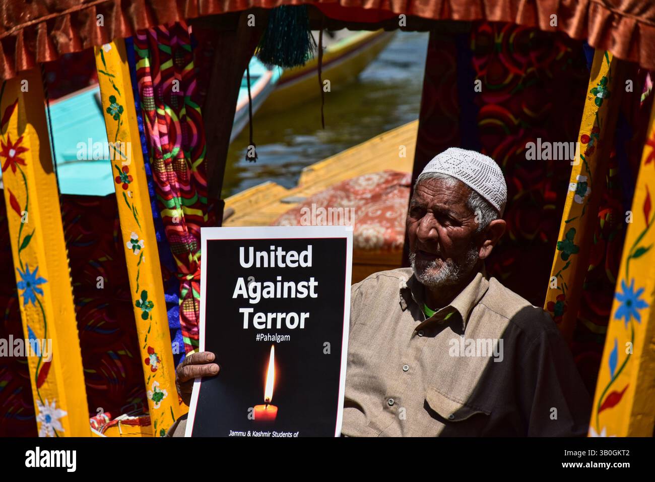 Srinagar, India. 24th Apr, 2025. A Kashmiri boatman holds a placard ...
