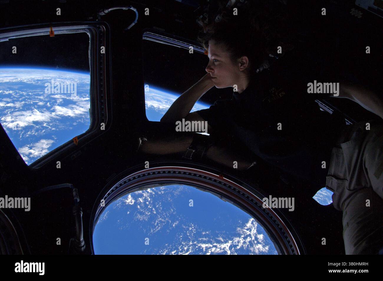 Sep 15, 2010 - There's no place like home. Peering out of the windows of the International Space Station (ISS), astronaut TRACY CALDWELL DYSON takes in the planet on which we were all born, and to which she would soon return. About 350 kilometers up, the ISS is high enough so that the Earth's horizon appears clearly curved. Astronaut Dyson's windows show some of Earth's complex clouds, in white, and life giving atmosphere and oceans, in blue. The space station orbits the Earth about once every 90 minutes. It is not difficult for people living below to look back toward the ISS. The ISS can freq Stock Photo