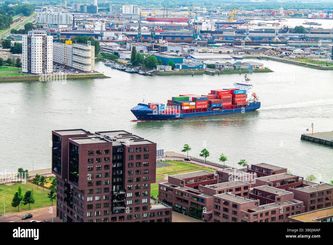 Aerial view of a busy port with a large container ship navigating the ...