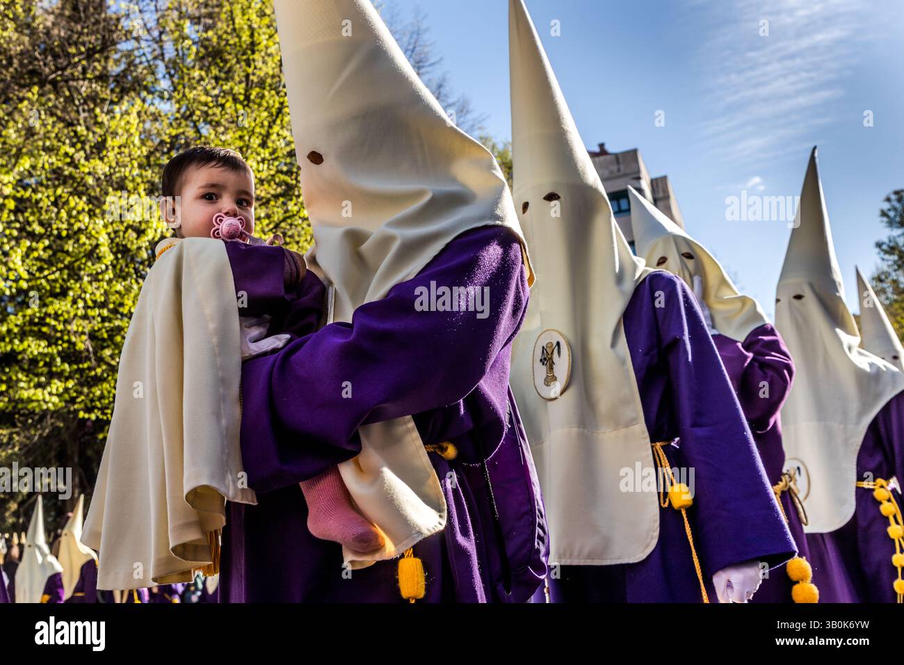 Procession in Spain with a child in the arms of a participant. Calle Aguirre, Cuenca, Castilla-La Mancha, Spain Stock Photo