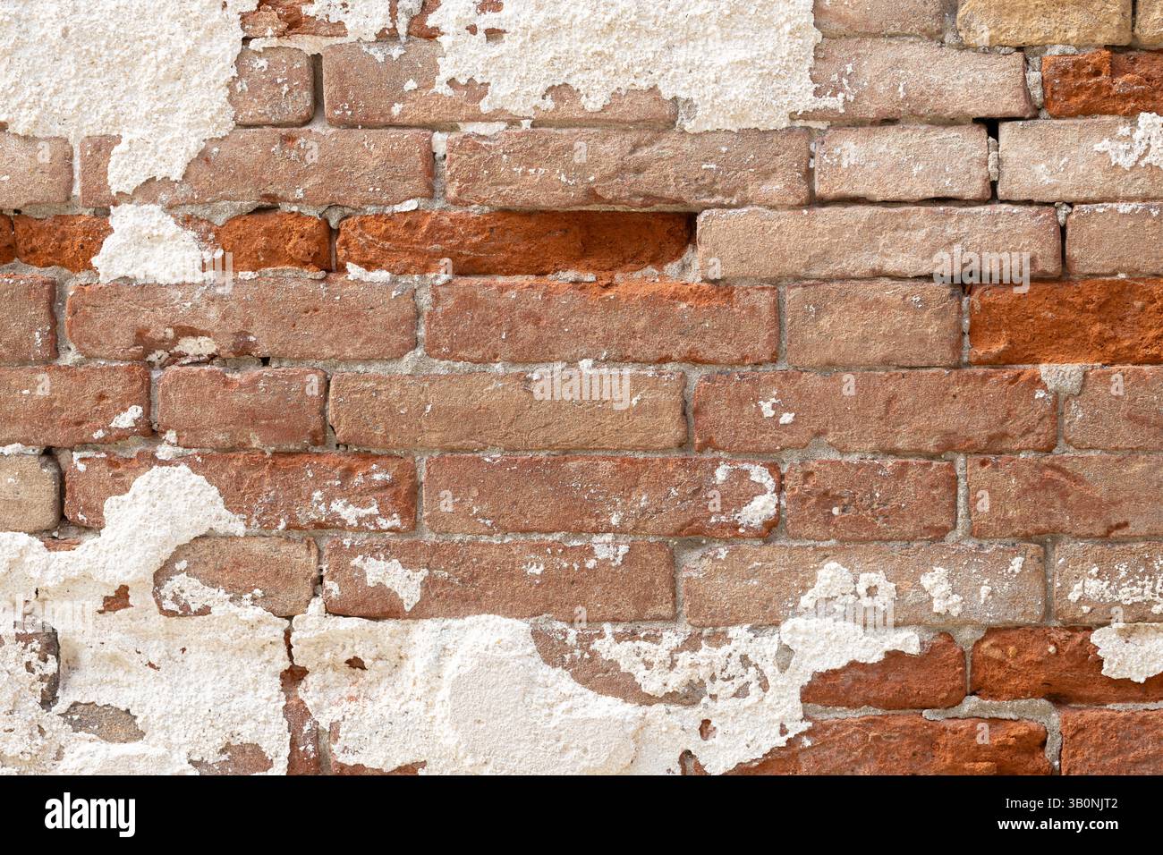 Aged Brick Wall with Peeling Plaster Stock Photo