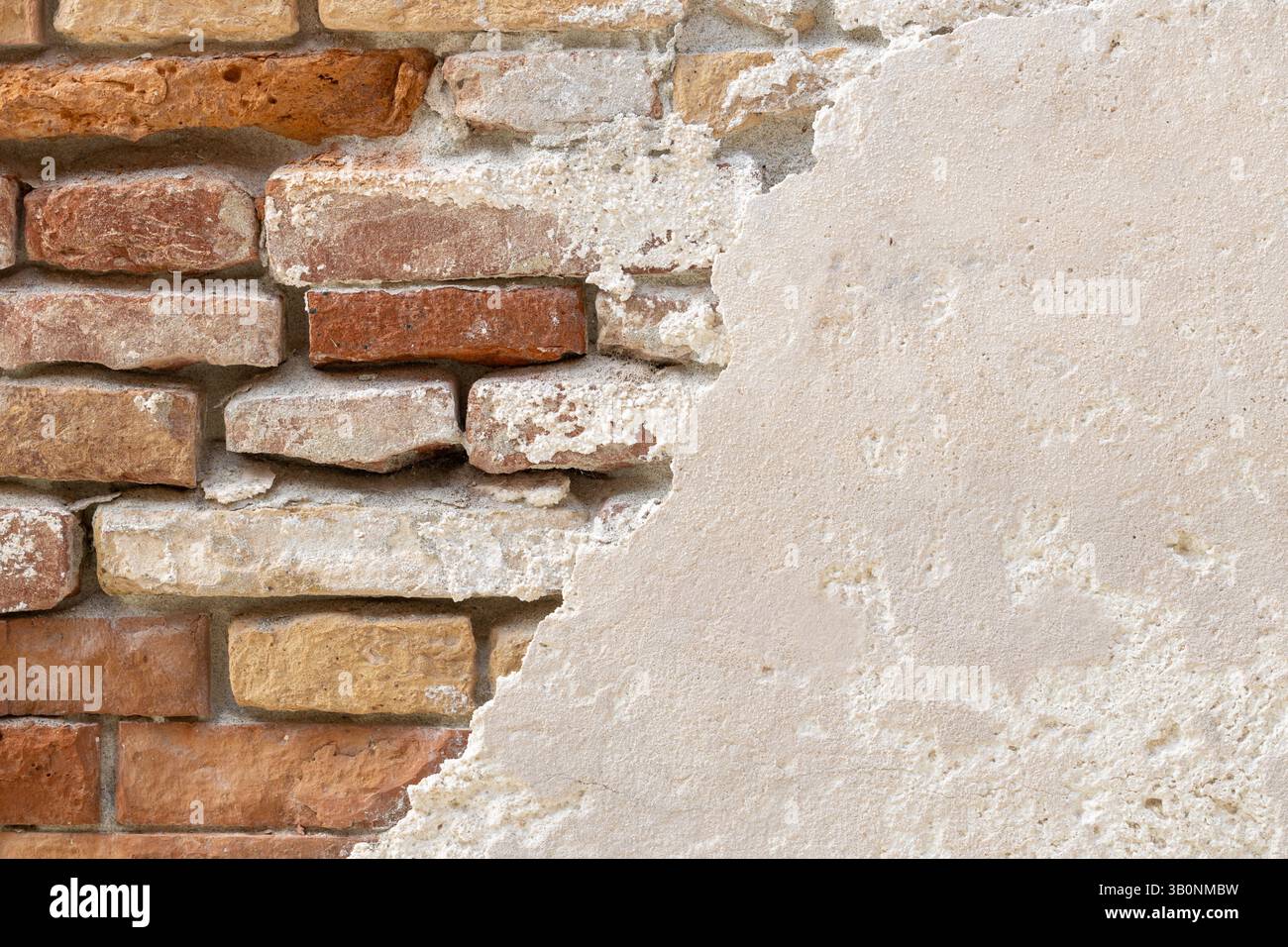 Old Brick Wall Revealed Under Plaster Stock Photo