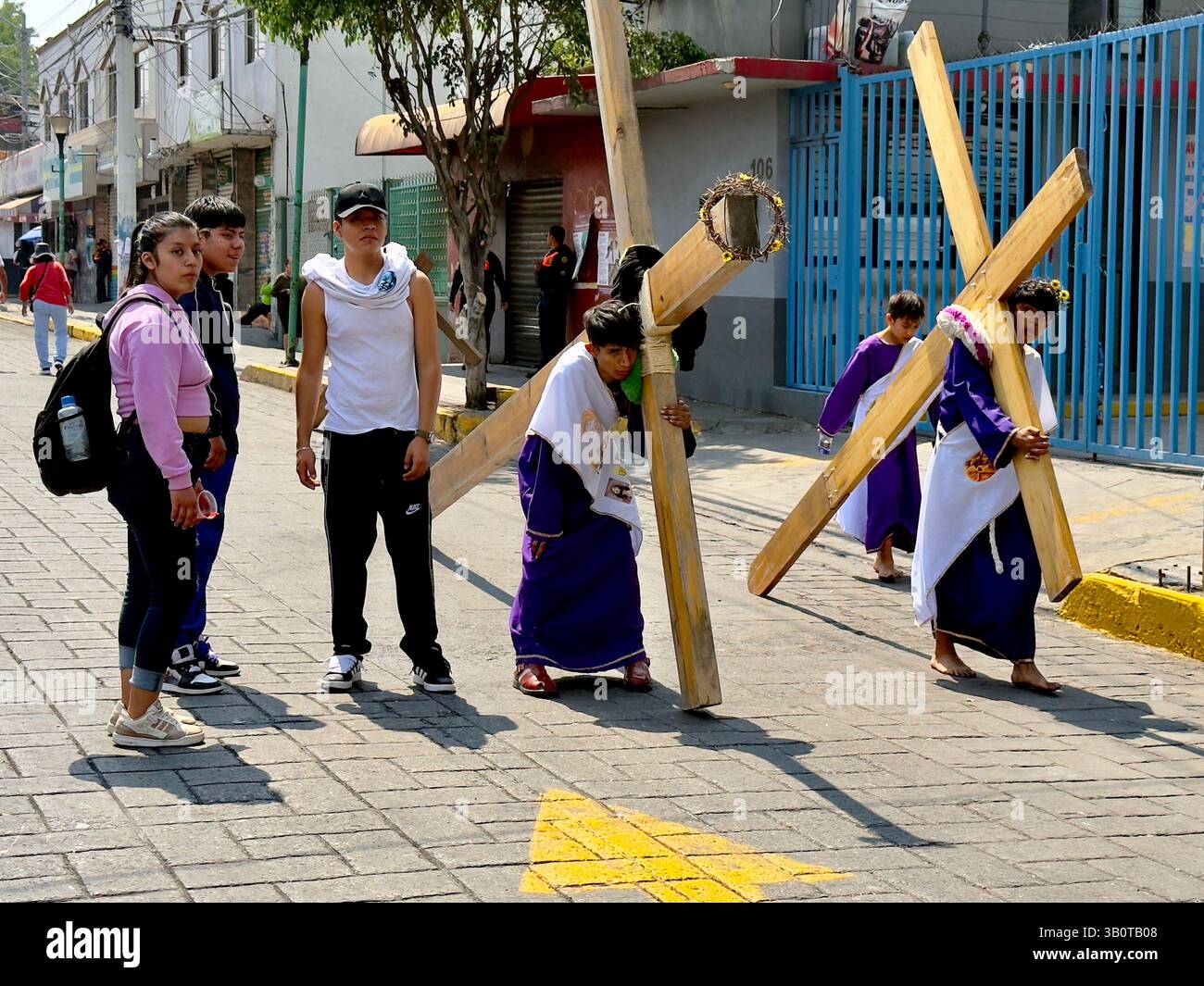 On Holy Friday in Iztapalapa, young faithful people carry large wooden ...