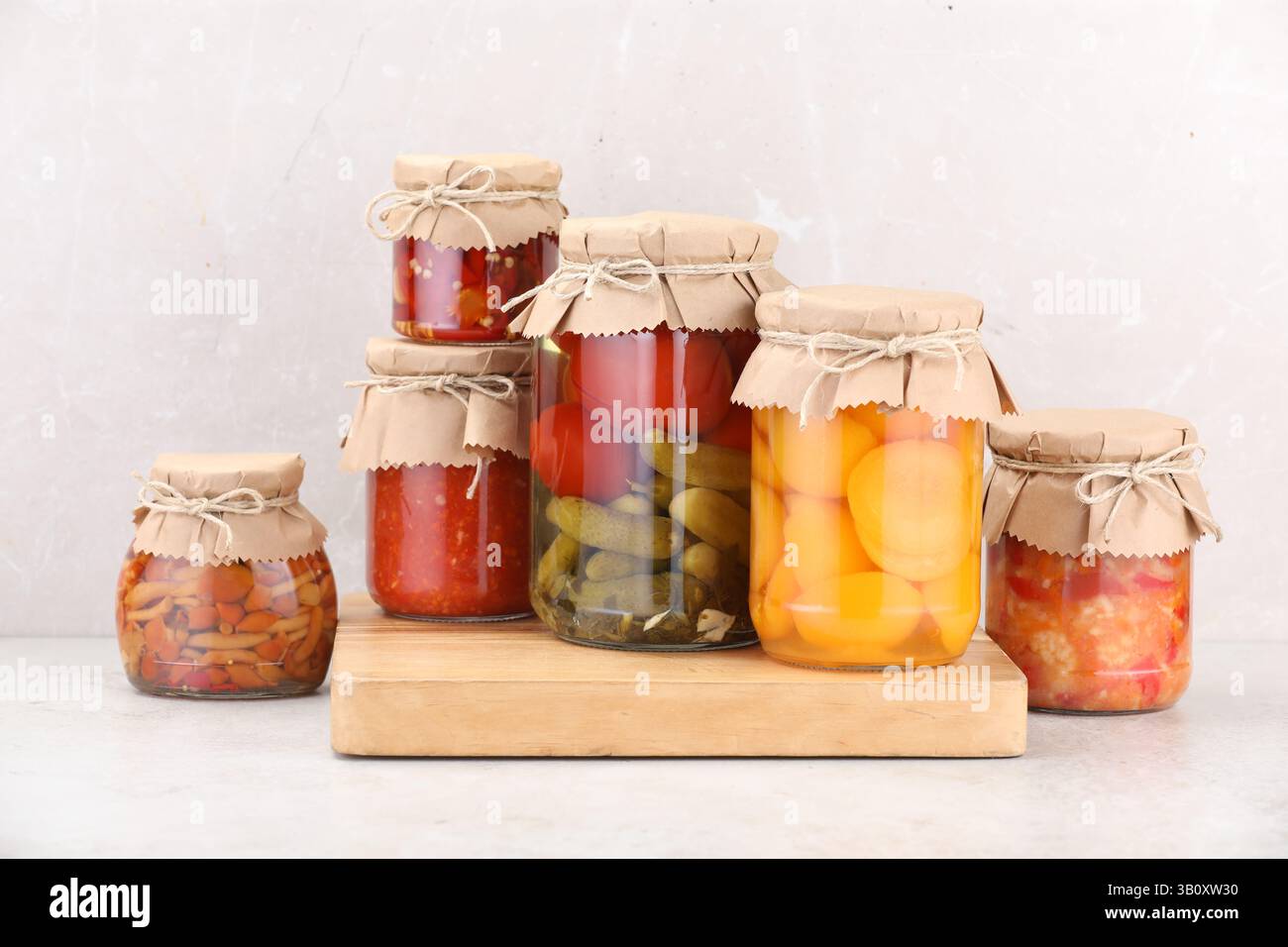 Many jars with different pickled products on light table Stock Photo