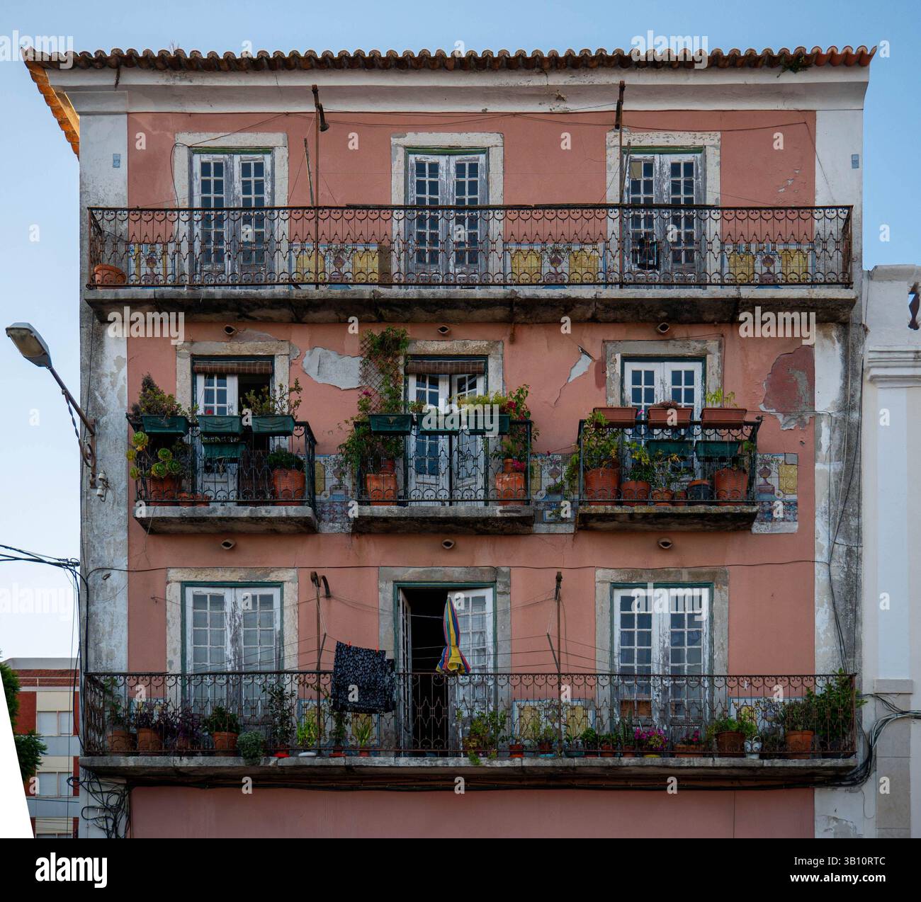 A delightful European building with a pink facade and three stories of ...