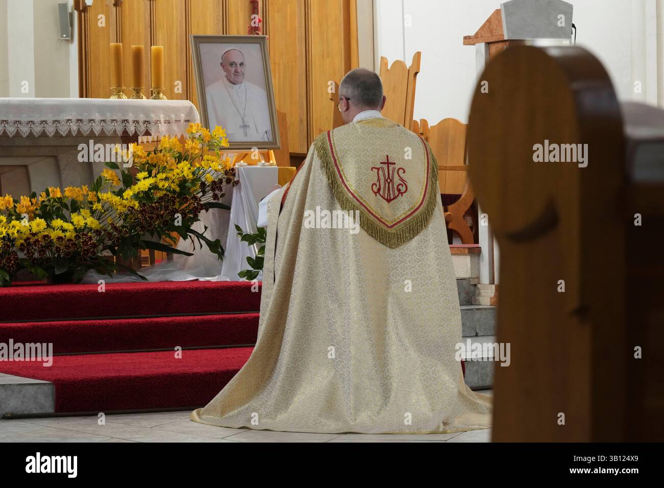 A catholic priest prays prior to a mass to commemorate the late Pope ...