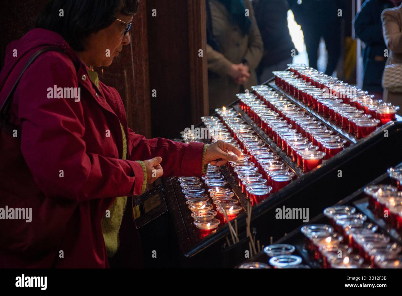 London, UK. 24th Apr, 2025. A female mourner lights up a tea candle to pay respect to Pope Francis at the Westminster Cathedral. The head of the Catholic Church, Pope Francis died on Easter Monday on 21st of April 2025 at the age of 88 in Vatican. Since Monday thousands of believers are going daily to the Westminster Cathedral in London to pay respect to him. Credit: SOPA Images Limited/Alamy Live News Stock Photo