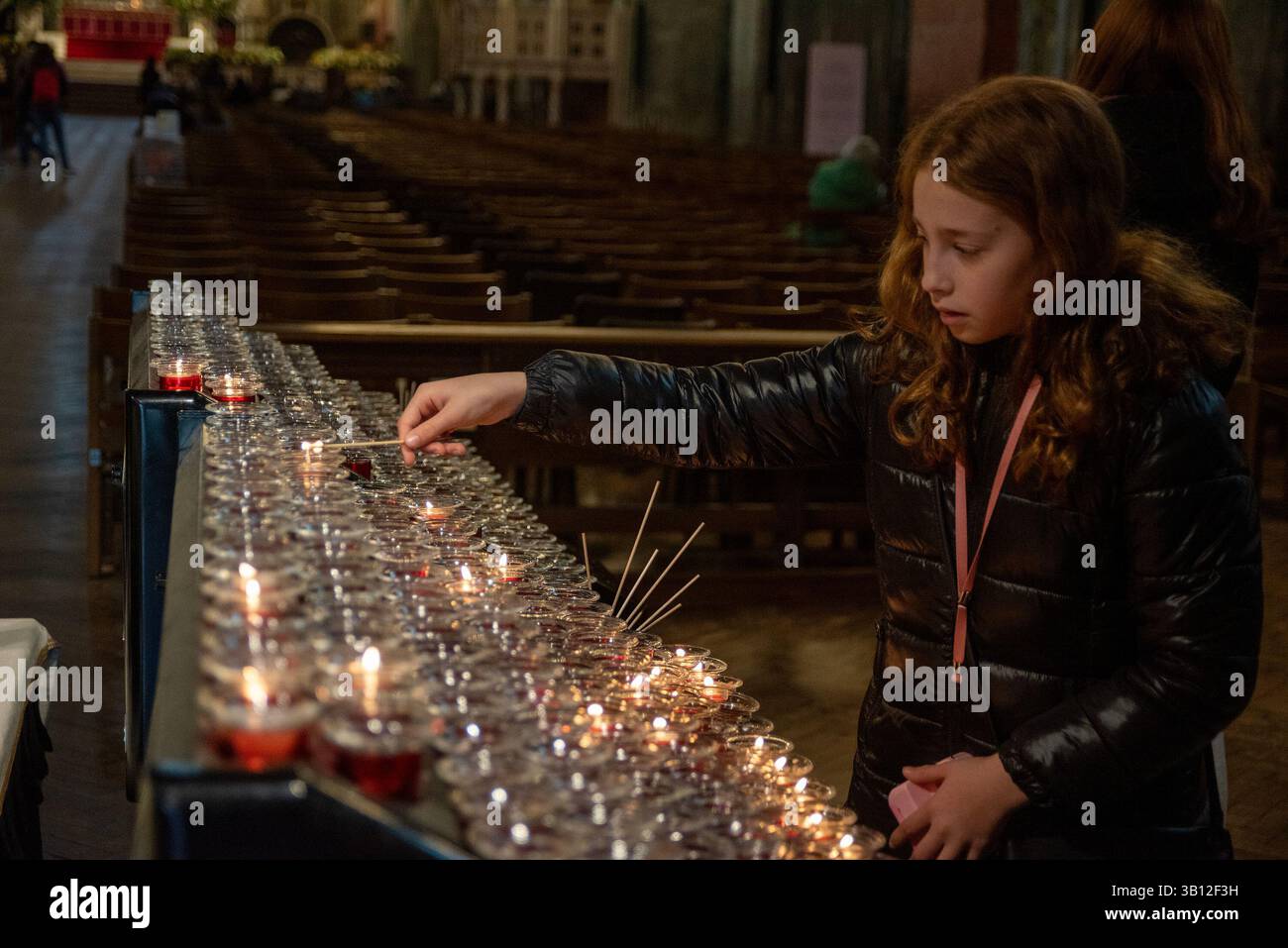 London, UK. 24th Apr, 2025. A young believer lights up a tea candle to pay respect to Pope Francis at the Westminster Cathedral. The head of the Catholic Church, Pope Francis died on Easter Monday on 21st of April 2025 at the age of 88 in Vatican. Since Monday thousands of believers are going daily to the Westminster Cathedral in London to pay respect to him. Credit: SOPA Images Limited/Alamy Live News Stock Photo