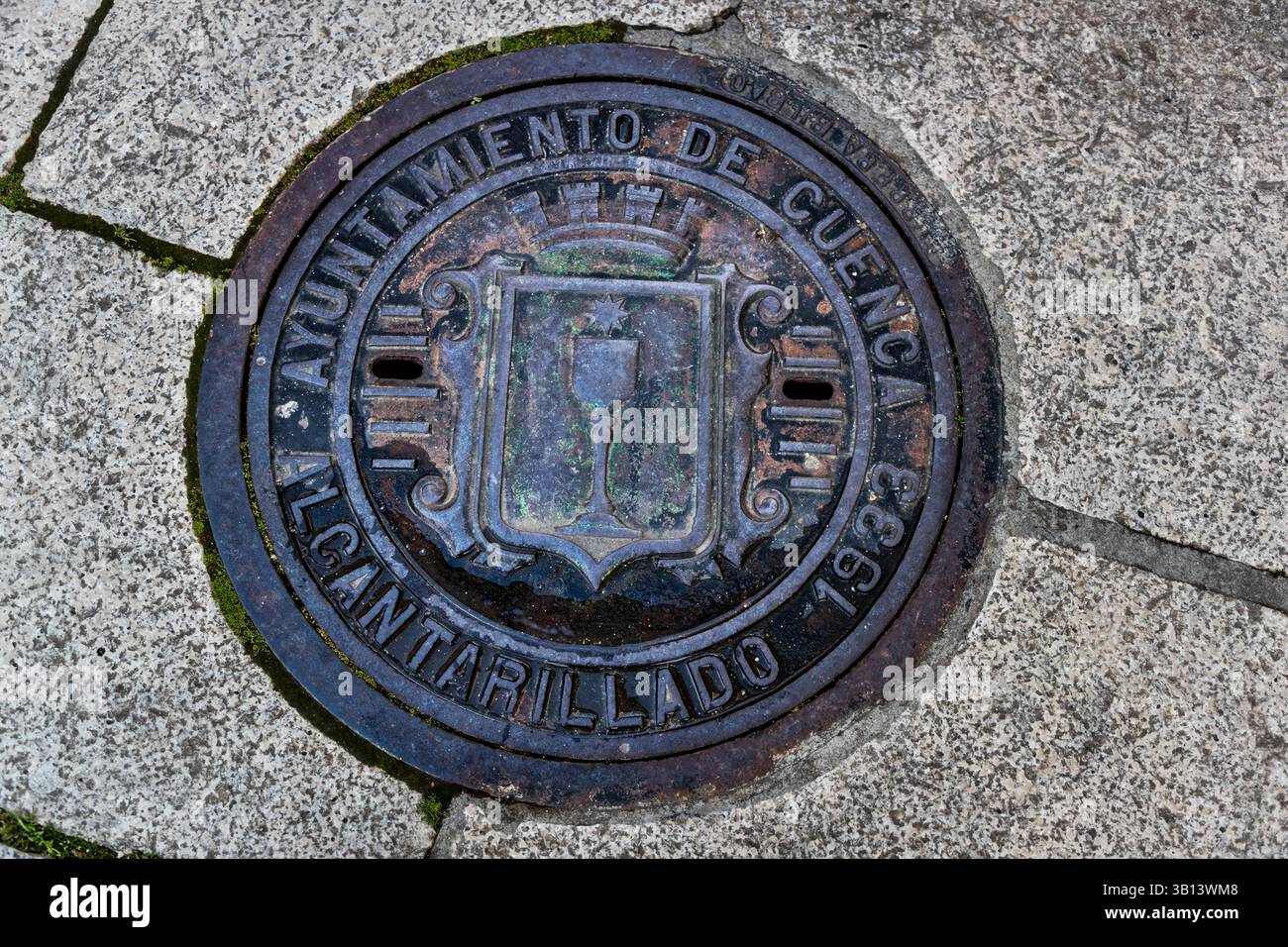 Sewage cover in Cuenca, Spain, with the city's coat of arms and the year 1933. Cuenca, Castilla-La Mancha, Spain Stock Photo