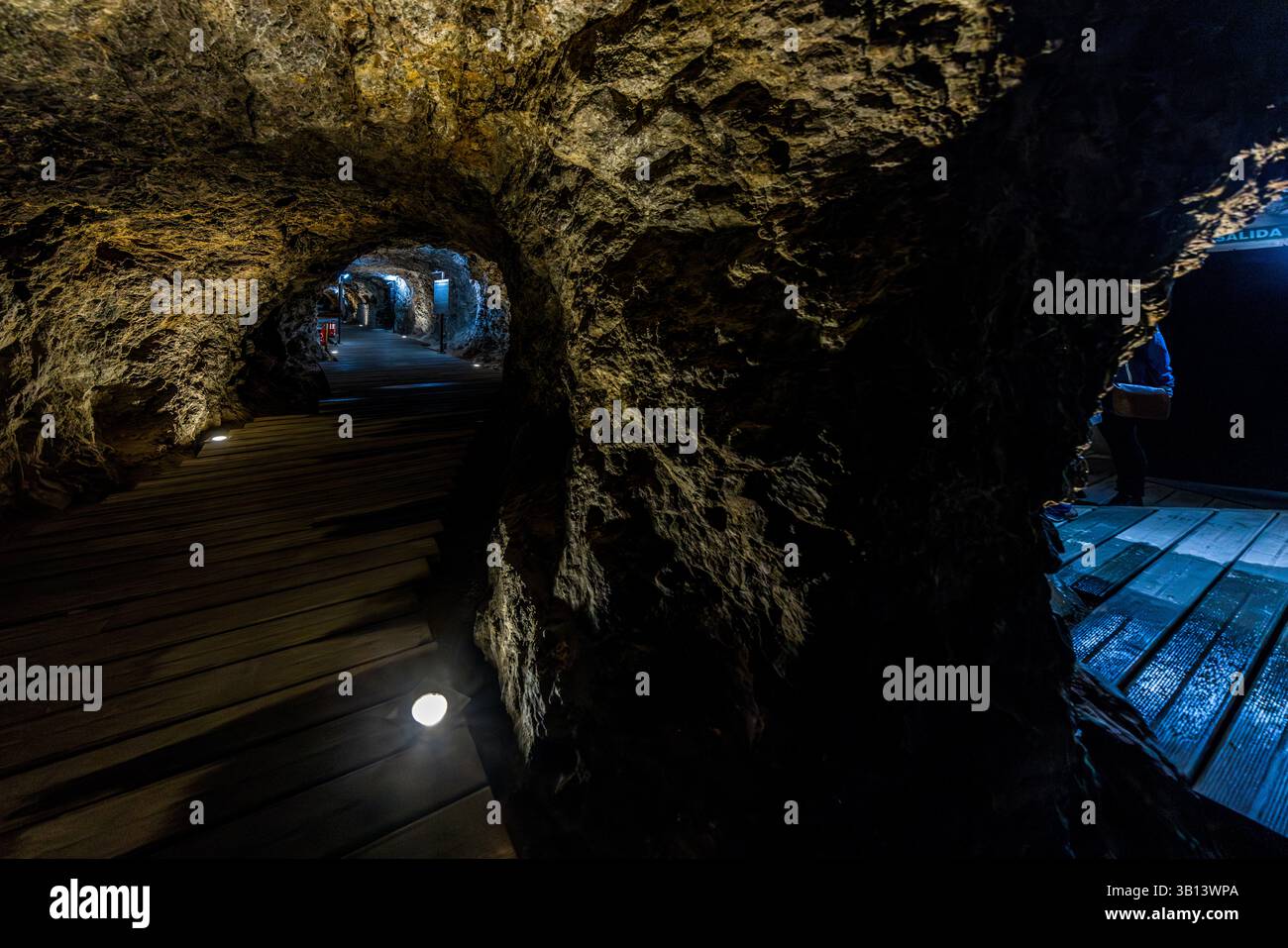 Visitors explore the Alphonso VIII underground tunnel in Cuenca. A wooden floor and lighting show the way. Calle Mosén Diego de Valera, Cuenca, Castilla-La Mancha, Spain Stock Photo