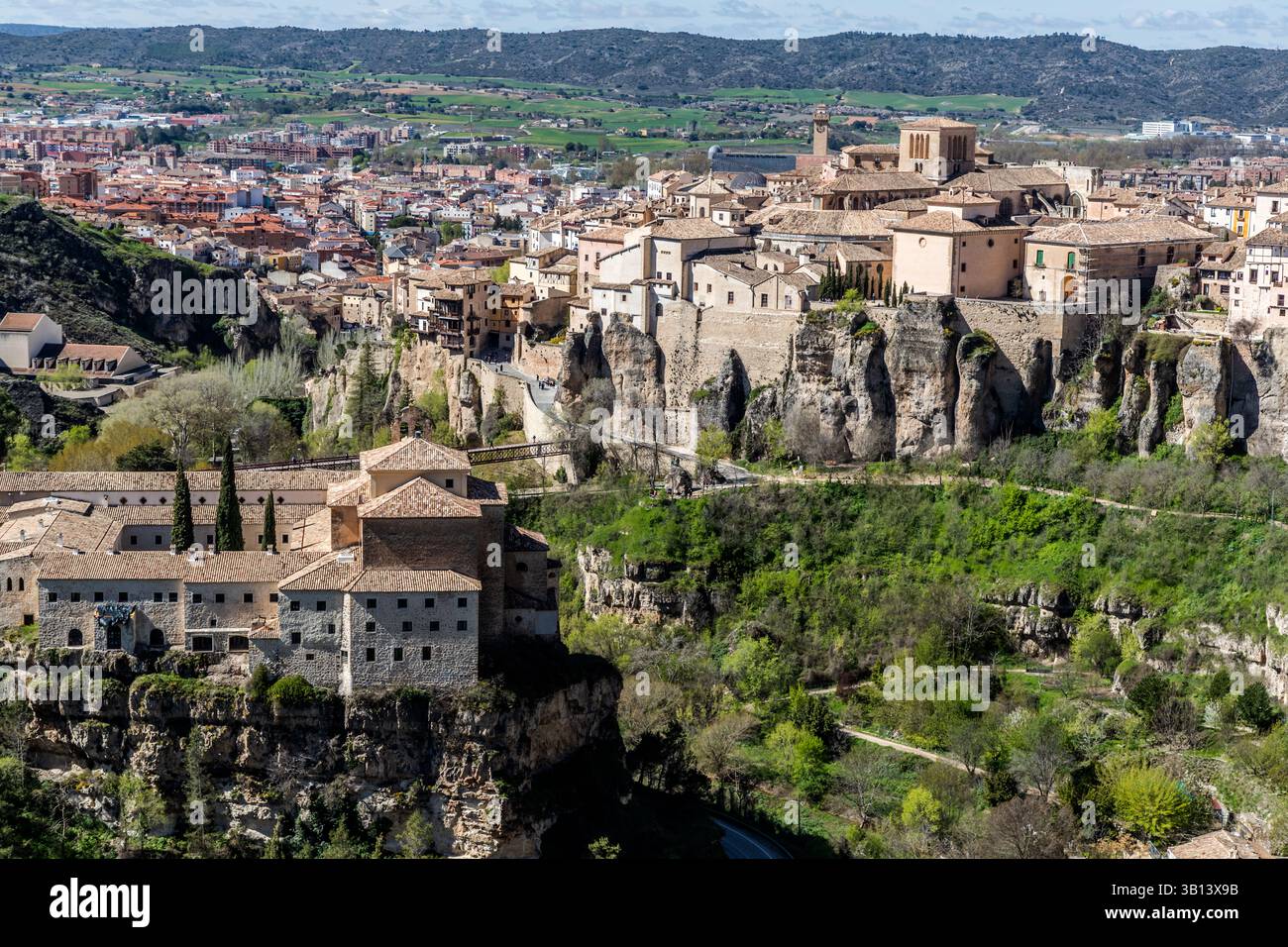 Panoramic view of Cuenca, Spain, with historic buildings on rocky outcrops and surrounding green landscapes. The landscape shows the unique topography and architecture of the city. Calle Larga, Cuenca, Castilla-La Mancha, Spain Stock Photo