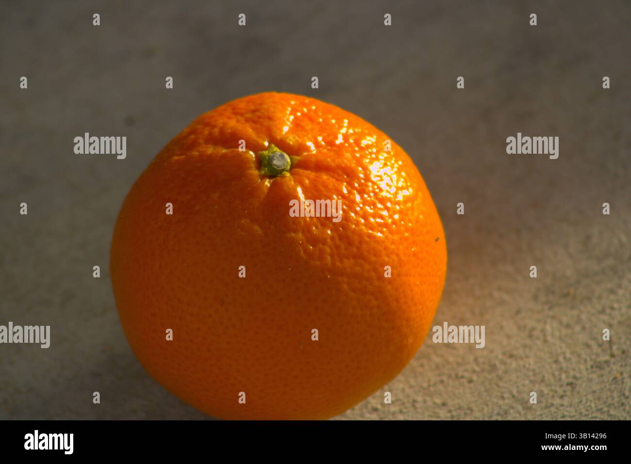 miniature orange sitting on pavement Stock Photo