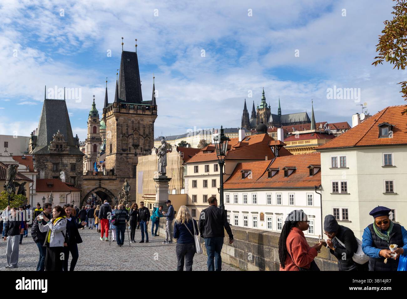 People walking along the cobbles on Charles bridge towards the lesser town district of Prague and towards Prague Castle Stock Photo