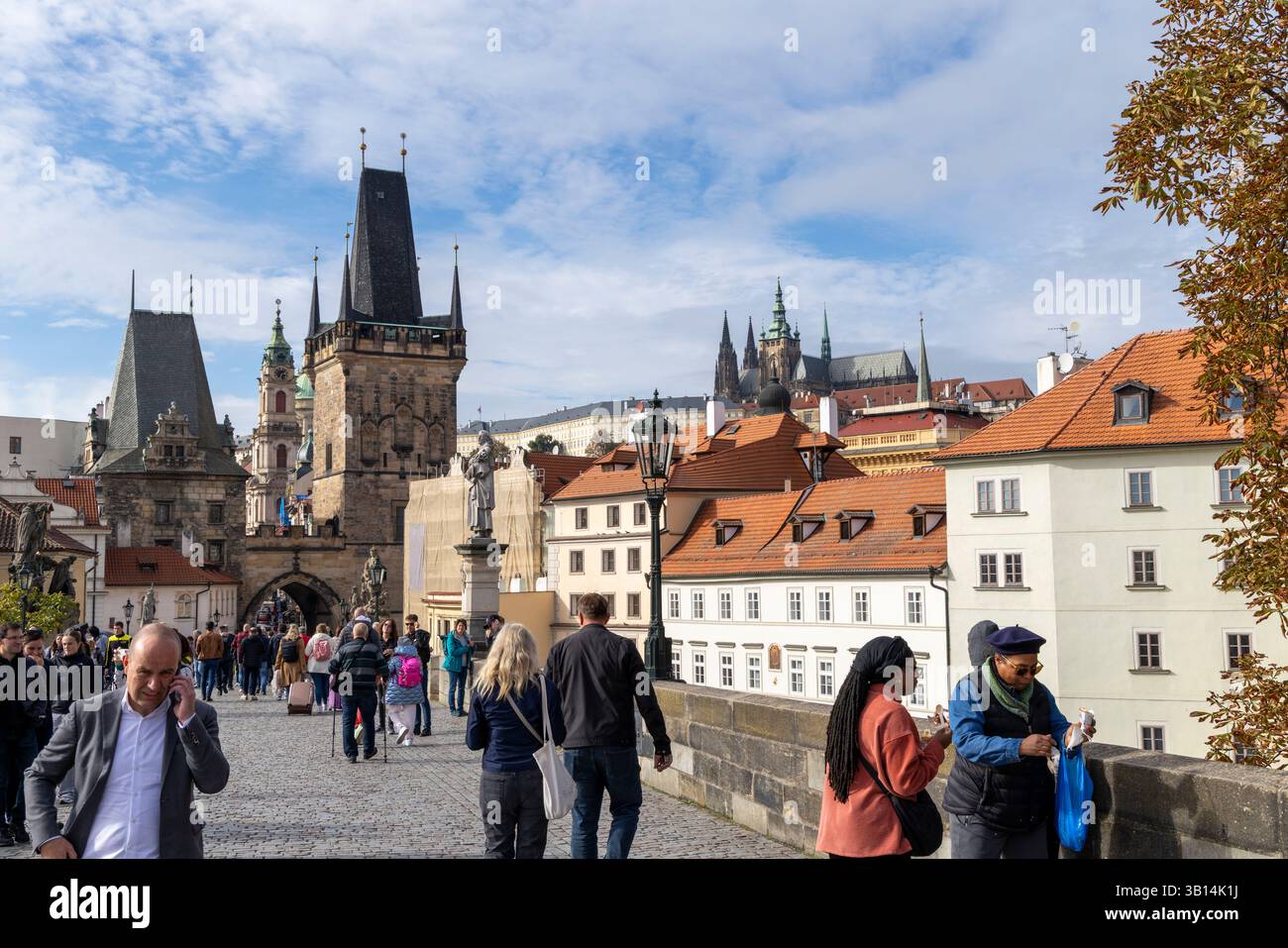 People walking along the cobbles on Charles bridge towards the lesser town district of Prague and towards Prague Castle Stock Photo