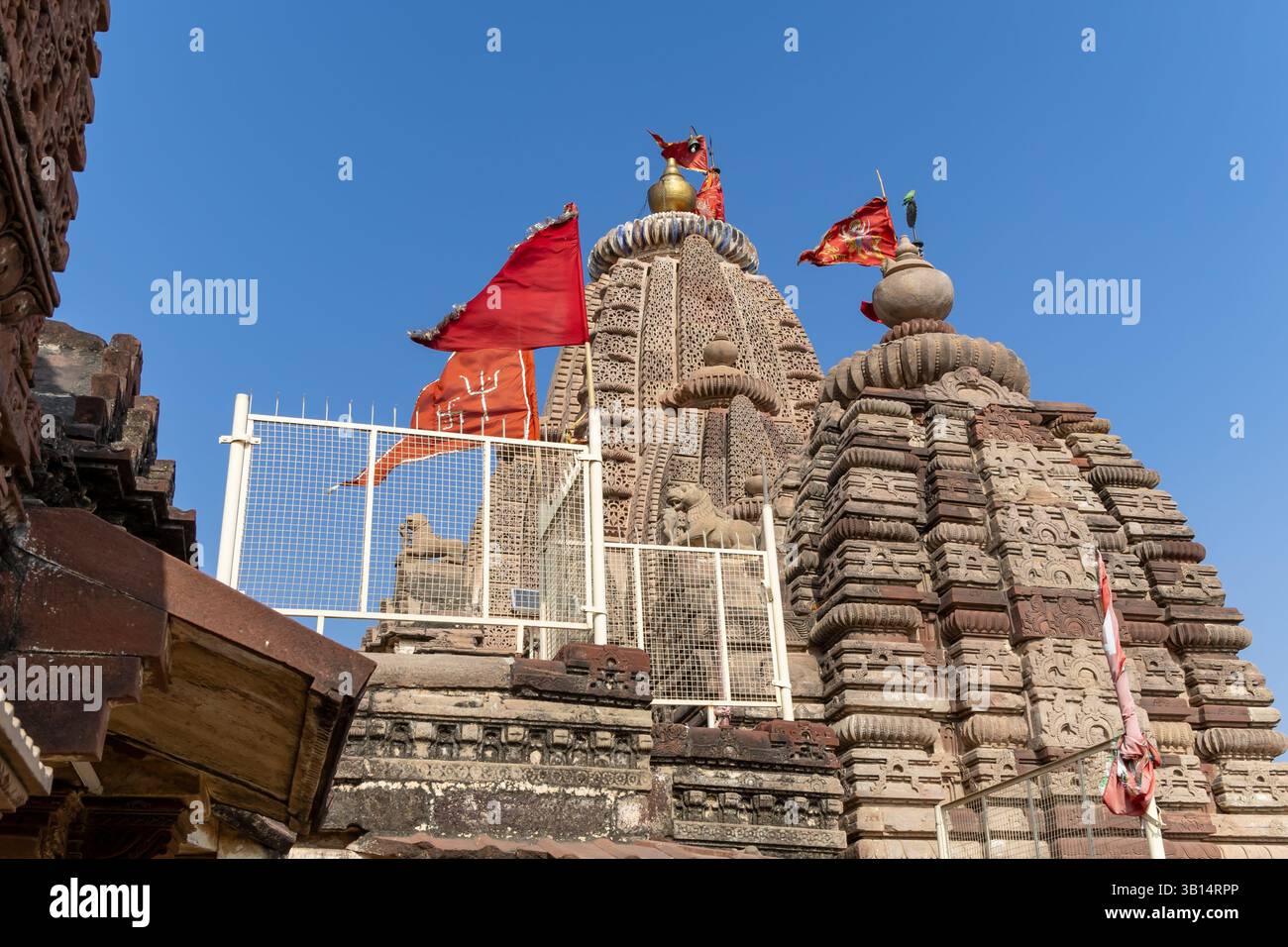 ancient hindu temple with waving holy flag and bright blue sky ...
