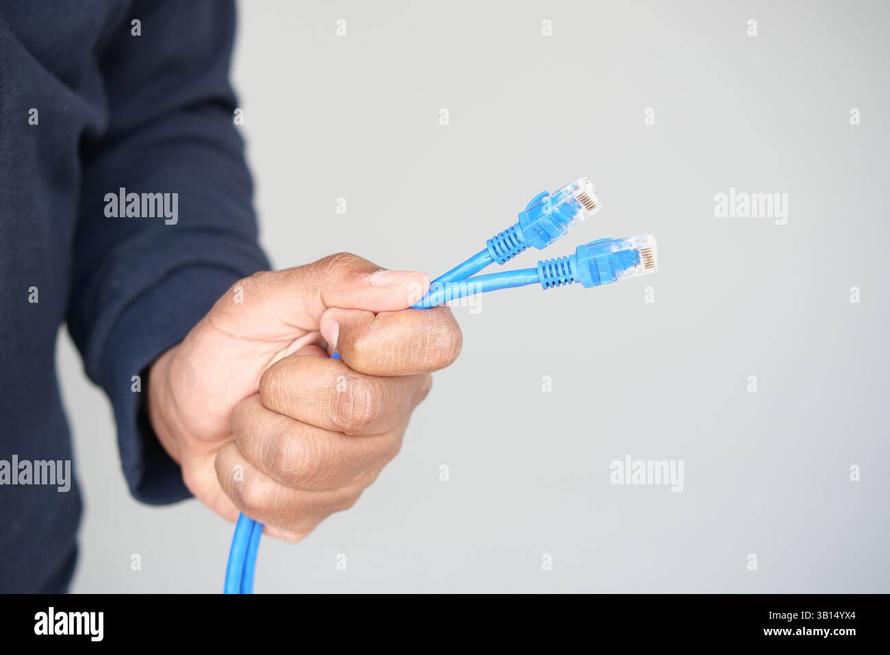 Holding multiple blue network cables for connection setup Stock Photo