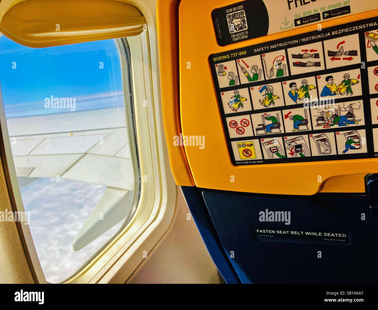 Ryanair flight safety instructions in flight view from window of wing. - Smartphone Captured Stock Image