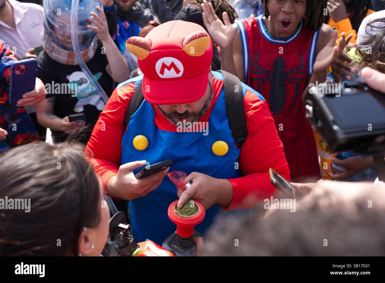 A person in a Super Mario costume prepares cannabis in a grinder ...