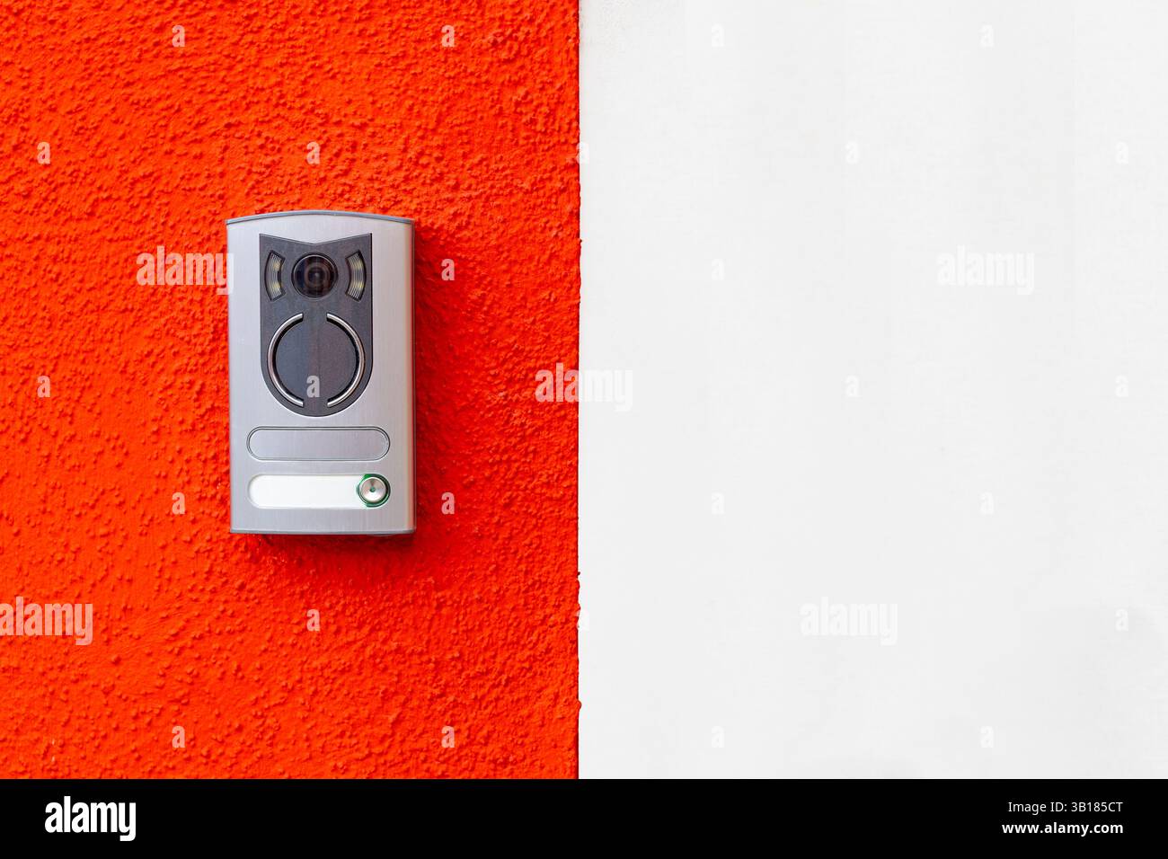 Modern door intercom on red and white wall Stock Photo