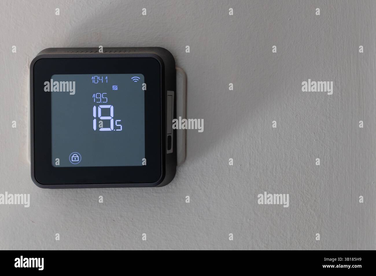 Smart digital thermostat on white wall Stock Photo