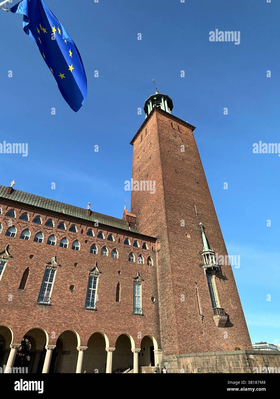 The Stockholm City Hall's iconic tower stands tall against a clear blue sky, a testament to its historical significance. - Smartphone Captured Stock Image