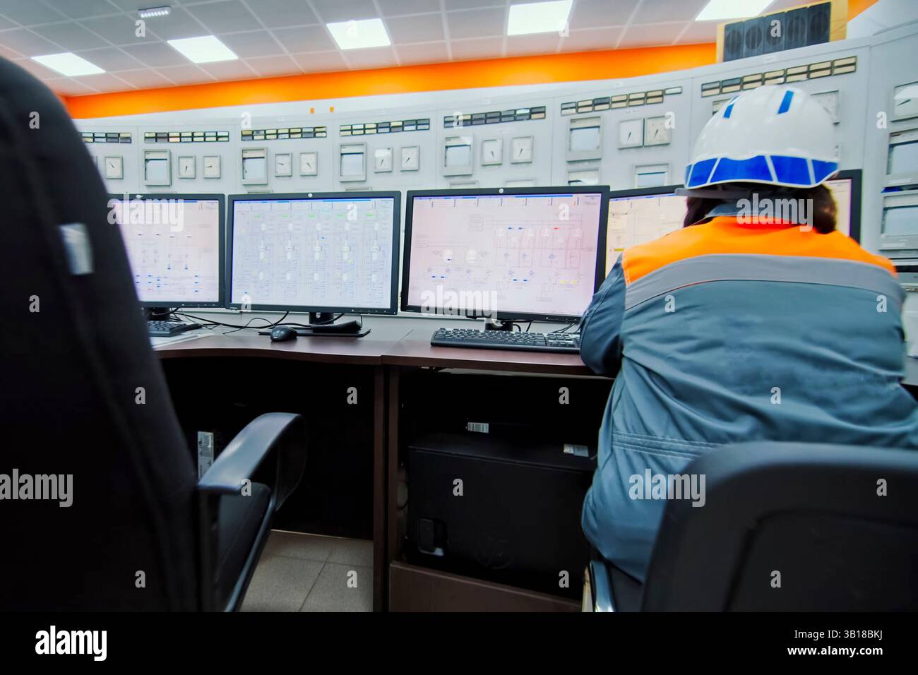 The control panel operator sits at the control panel and works. Stock Photo