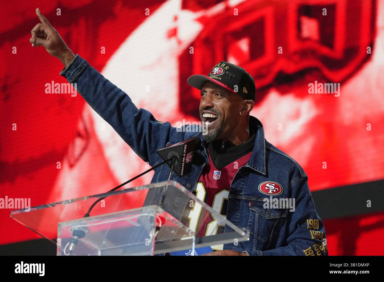 Former NFL player Julian Peterson reacts before announcing a pick by