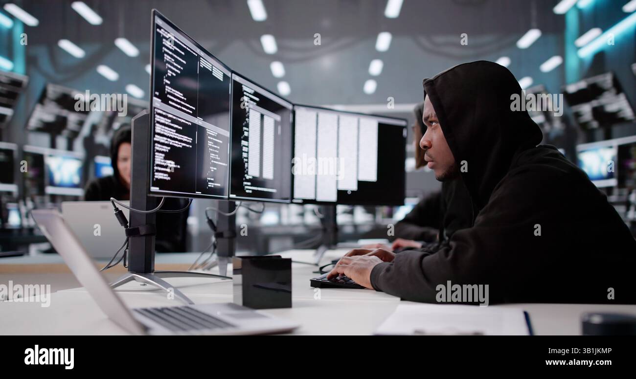 Hooded Programmer Stealing Secure Data And Information From Computer Screen. Stock Photo