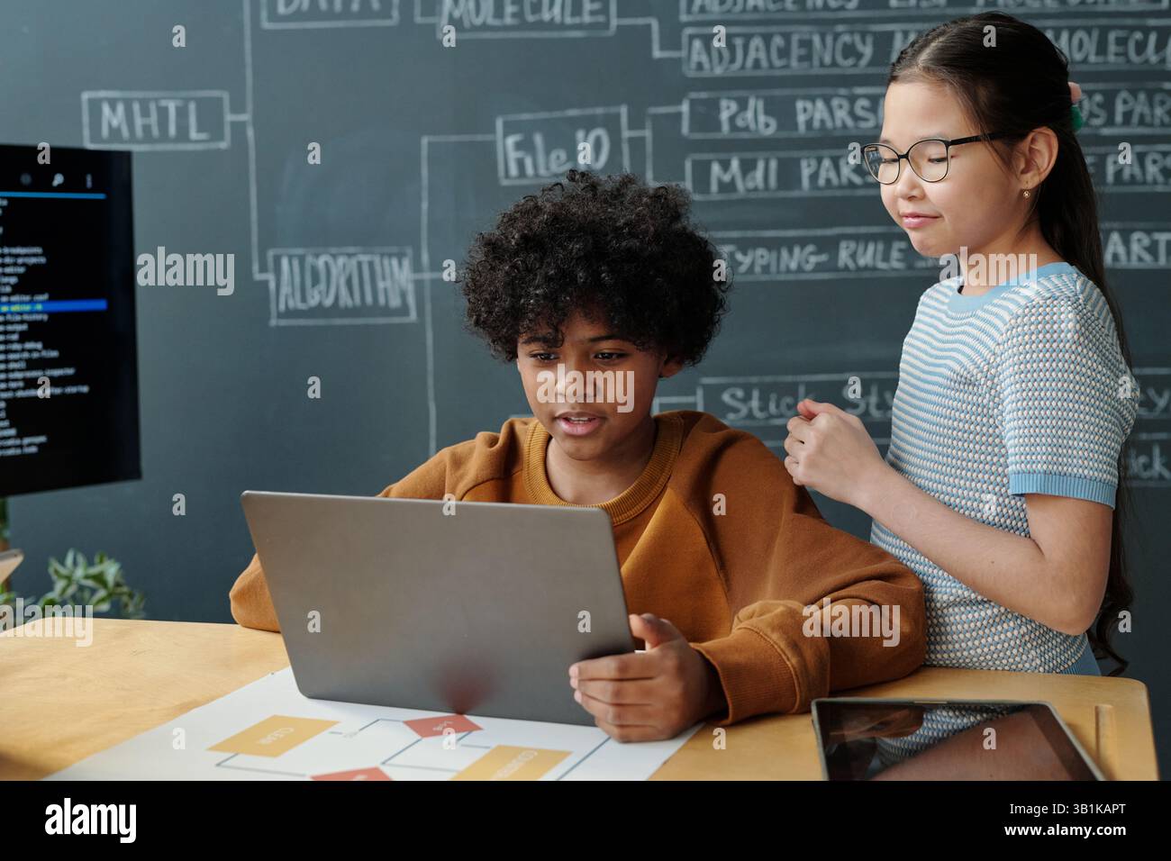 Collaborating on School Project with Laptop and Notes Stock Photo