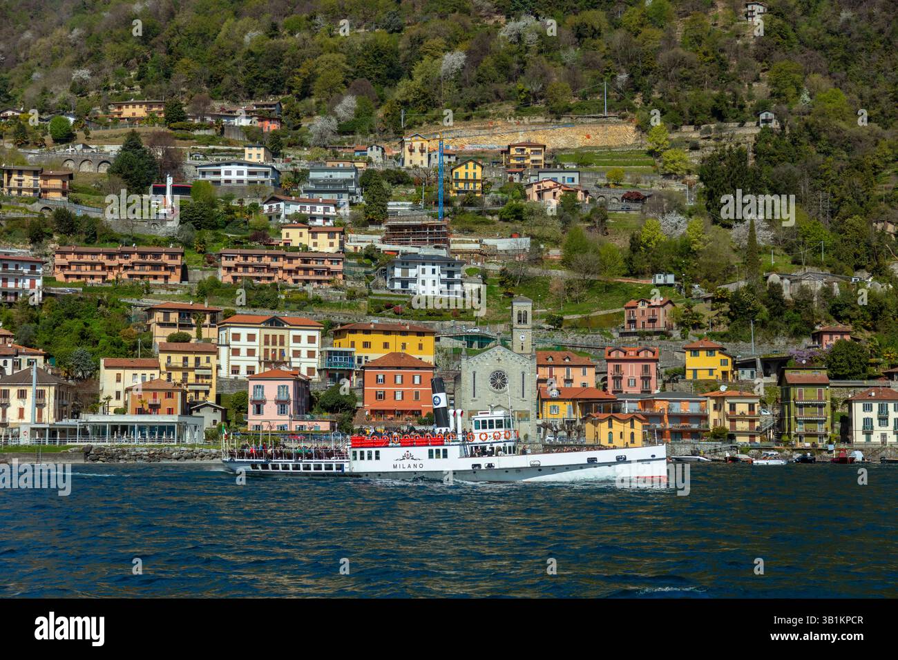 Rundfahrtschiff mit Menschen vor Argegno am Comer See, Lombardei, Italien Stock Photo