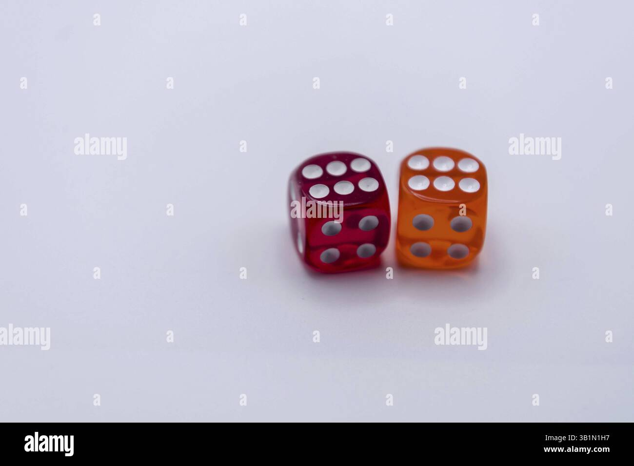 Two translucent dice in red and orange on a light background Stock Photo