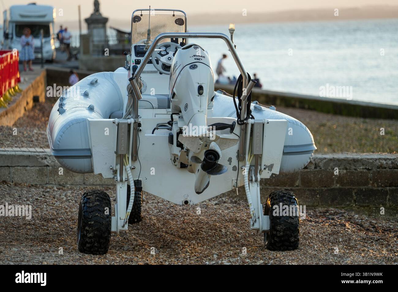 Small Rib Sailing A small RIB boat with all-terrain wheels sits on a shingle beach at ...
