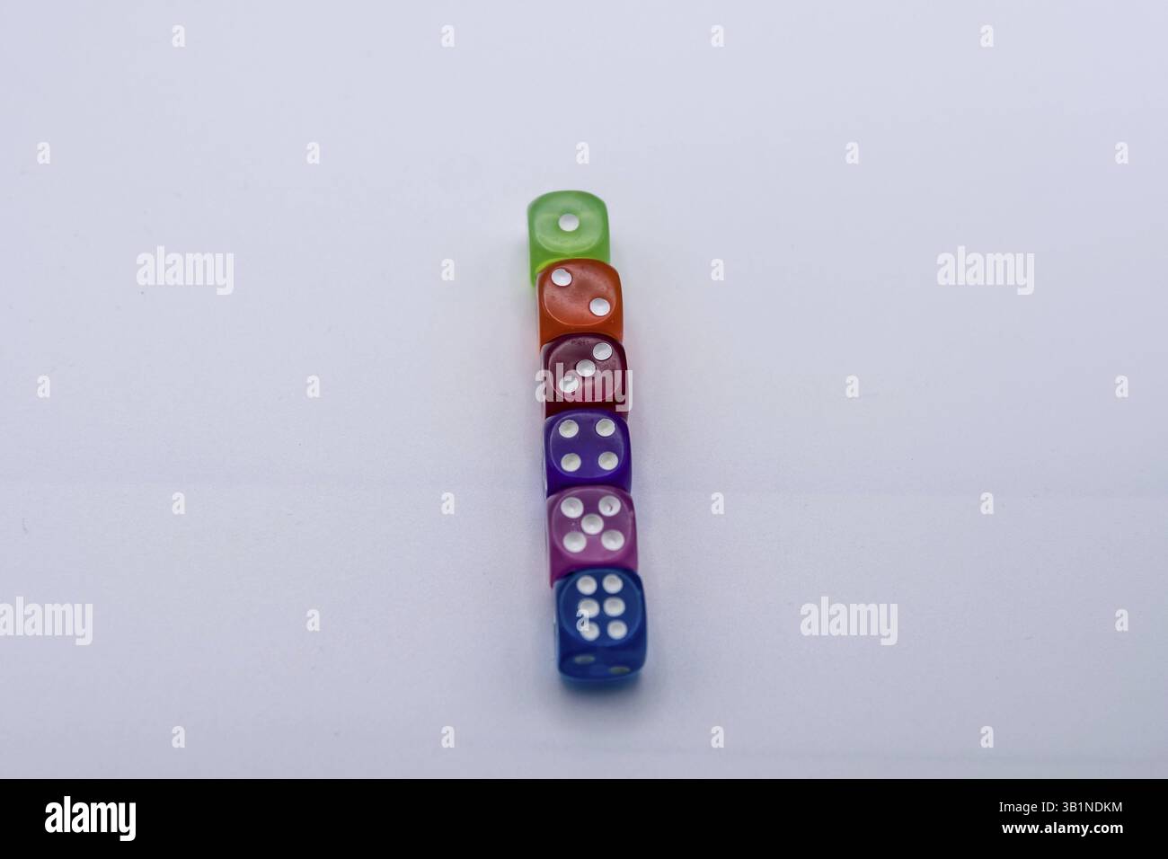Vertical stack of colorful translucent dice on a light background Stock Photo